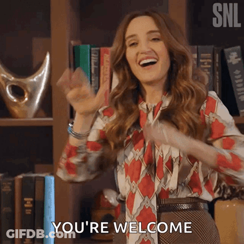 Woman Saying You're Welcome In Front Of Bookshelf GIF