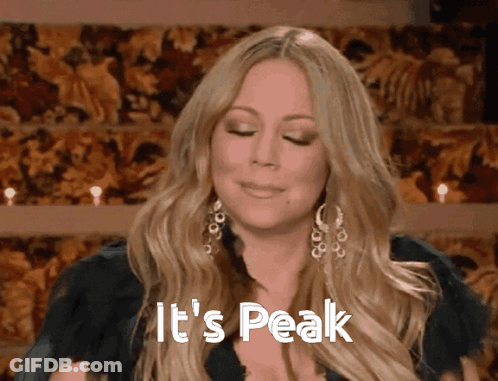 Woman Says It's Peak In Front Of Floral Backdrop GIF