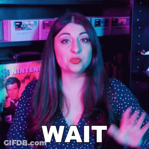Woman Says Wait In Front Of Video Games GIF