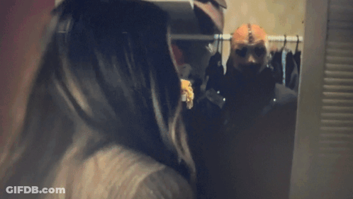 Woman Screaming Behind Man Sitting On Bed GIF