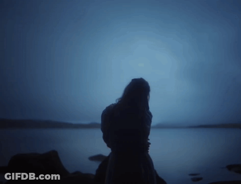 Woman Silhouette Standing On Rock Near Water GIF