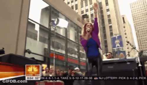 Woman Singing In Front Of Crowd With NBC Logo GIF