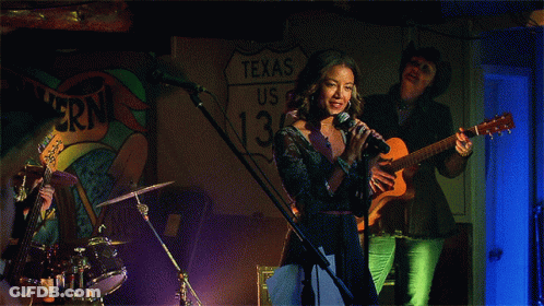 Woman Singing In Front Of Texas Sign GIF