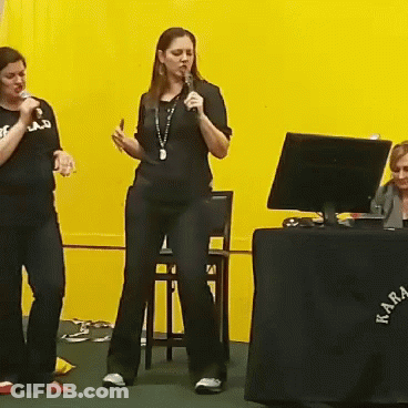 Woman Singing Into Microphone At Akra Table GIF