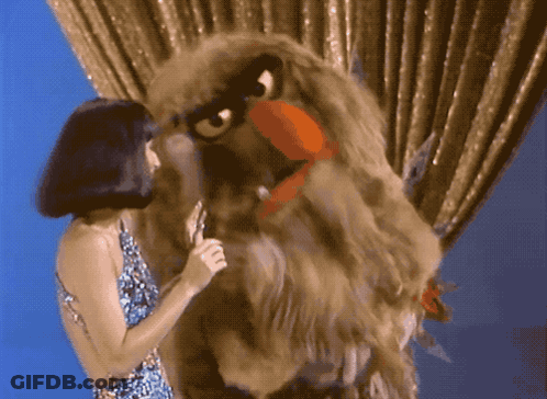 Woman Singing Into Microphone Beside Eagle Puppet GIF