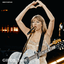 Woman Singing Into Microphone Holding Guitar Making Heart Shape GIF
