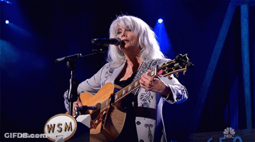 Woman Singing Into Microphone Holding Guitar With WSM Logo GIF