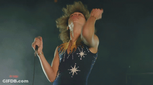 Woman Singing Into Microphone In Blue Dress With Stars GIF