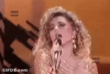 Woman Singing Into Microphone In Front Of Beca Sign GIF