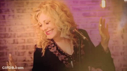 Woman Singing Into Microphone In Front Of Brick Wall GIF