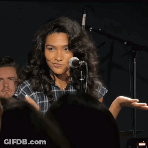Woman Singing Into Microphone In Front Of Crowd GIF