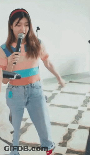 Woman Singing Into Microphone In Jeans And Headband GIF