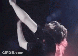 Woman Singing Into Microphone On Stage Arms Outstretched GIF