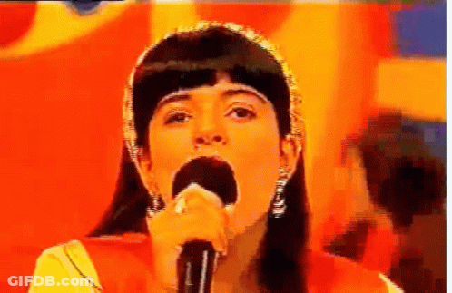 Woman Singing Into Microphone Orange Background GIF