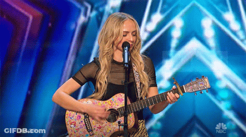 Woman Singing Into Microphone Playing Guitar NBC GIF