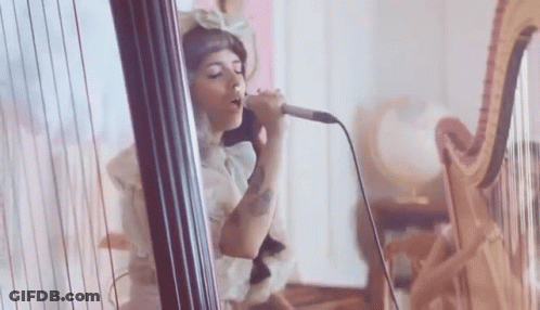 Woman Singing Into Microphone Playing Harp GIF