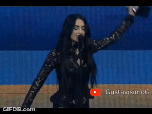 Woman Singing Into Microphone Wearing Epine Shirt GIF