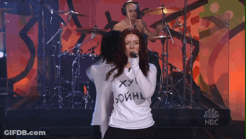Woman Singing Into Microphone Wearing XXL Shirt GIF