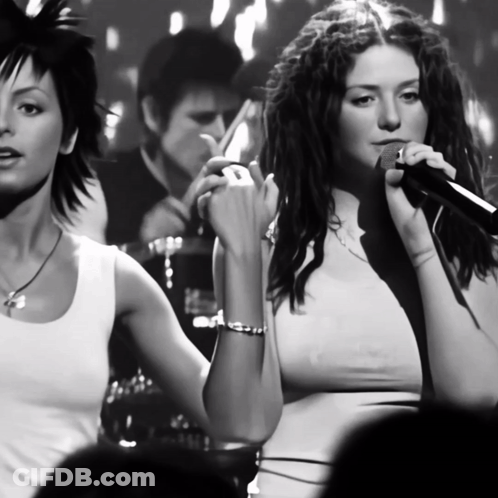 Woman Singing Into Microphone With Another Woman Behind GIF