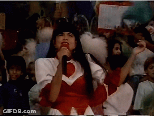 Woman Singing Into Microphone With Crowd And TCS Shirt GIF