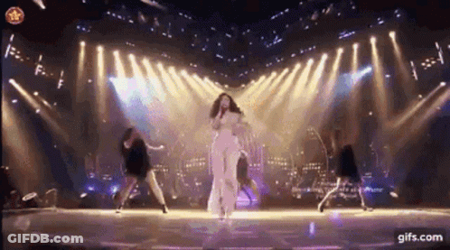 Woman Singing Into Microphone With Dancers GIF