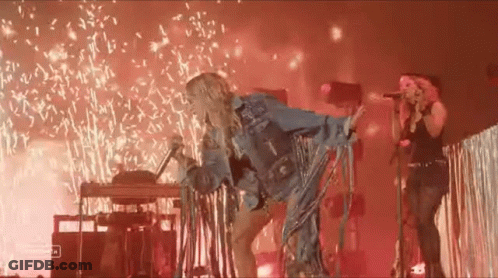 Woman Singing Into Microphone With Fireworks GIF