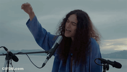 Woman Singing Into Microphone With Fist In Air GIF