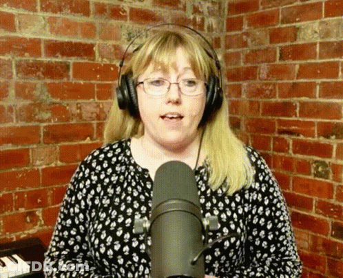 Woman Singing Into Microphone With Glasses And Headphones GIF