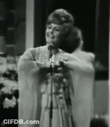 Woman Singing Into Microphone With Letters VE GIF