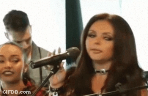 Woman Singing Into Microphone With Man Behind GIF