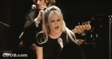 Woman Singing Into Microphone With Man Playing Guitar GIF