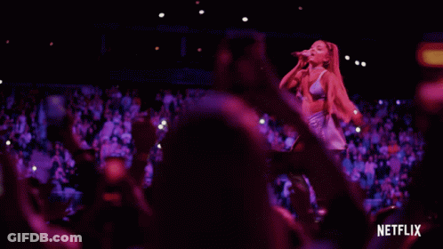 Woman Singing Into Microphone With Netflix Logo And Crowd GIF