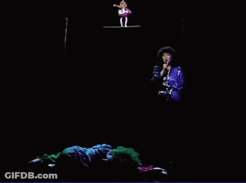 Woman Singing Into Microphone With Two Clowns GIF