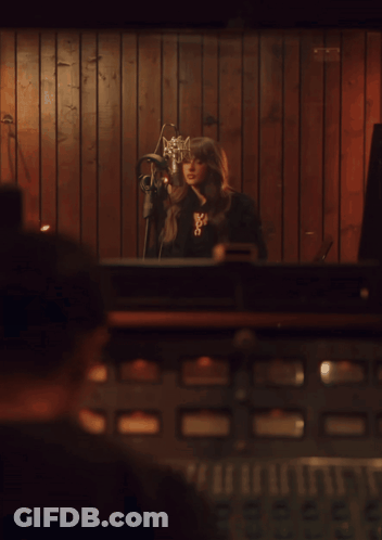 Woman Singing Into Microphone With X Necklace GIF