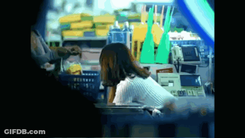Woman Sits At Counter In Front Of Machine Saying A GIF