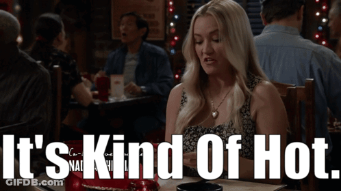 Woman Sits At Table Saying It's Kind Of Hot GIF