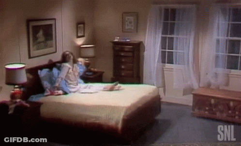 Woman Sits On Bed In Bedroom With SNL GIF