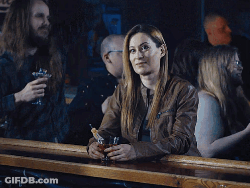 Woman Sitting At Bar Holding Drink GIF
