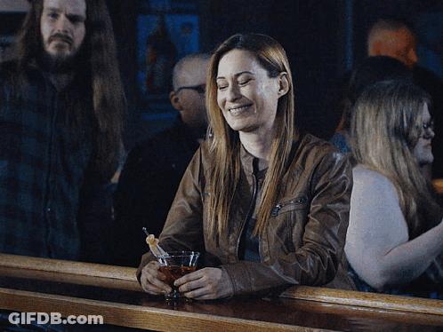Woman Sitting At Bar Holding Martini GIF