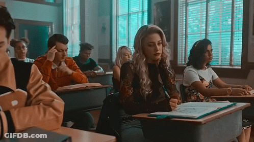 Woman Sitting At Desk In Classroom GIF