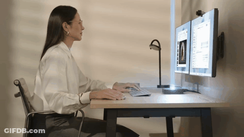 Woman Sitting At Desk Using Computer GIF