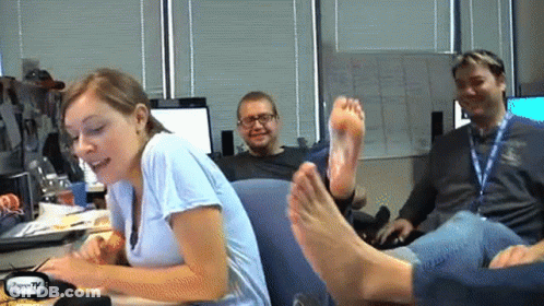 Woman Sitting At Desk With Feet On Man GIF