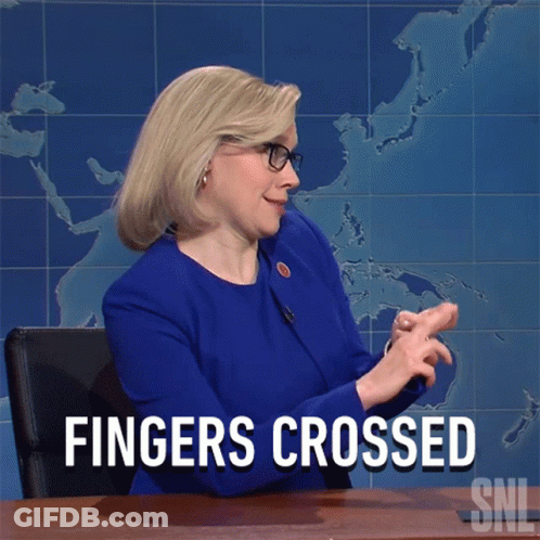 Woman Sitting At Desk With Hands Crossed Saying Fingers Crossed GIF