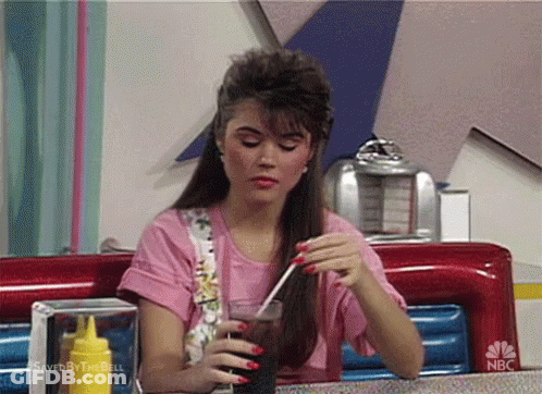Woman Sitting At Diner Table Holding Soda GIF
