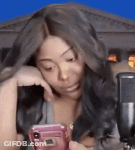 Woman Sitting At Microphone Looking At Phone GIF