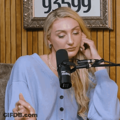 Woman Sitting At Microphone With Sign 93599 GIF
