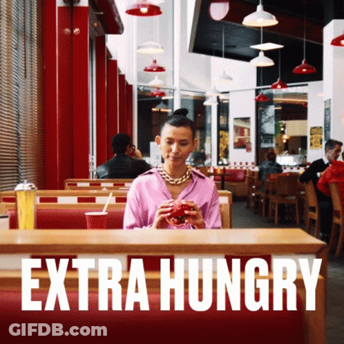 Woman Sitting At Restaurant Saying Extra Hungry GIF