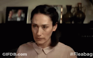 Woman Sitting At Shelf With Vases And Picture GIF