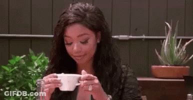 Woman Sitting At Table Drinking Cup GIF