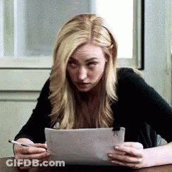 Woman Sitting At Table Holding Paper GIF
